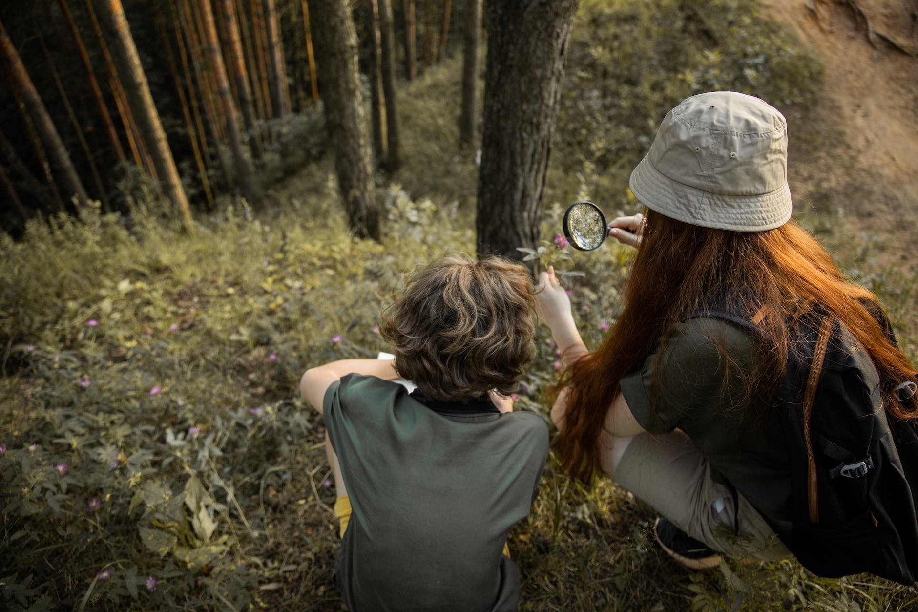discovering your core values -- teenagers on an adventure in a forest and looking through a loupe
